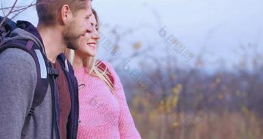 快乐夫妇回来自然年轻的金发女郎女孩微笑高加索人男人。背包肩膀微笑
